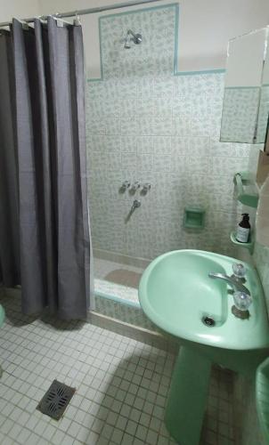 y baño con lavabo y ducha. en Azul Puan Suites en Azul