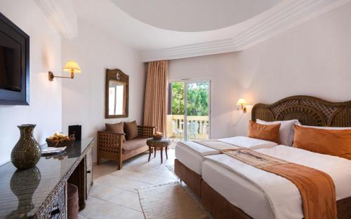 a bedroom with a large bed and a living room at Africa Jade Thalasso in Korba