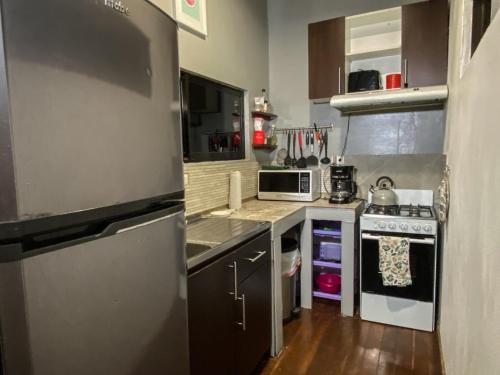 a small kitchen with a stove and a microwave at CASA NATURaL in Brasilito