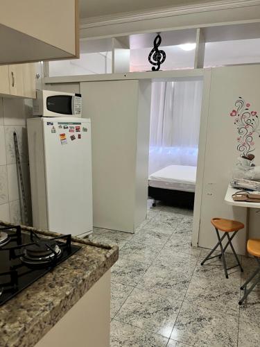 cocina con nevera, mesa y cama en Apartamento Studio 806, en Fortaleza