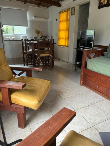 a living room with wooden furniture and a dining room at Cabañas Valle Del Sol in Tandil