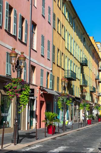 a street lined with buildings with potted plants and street lights at Hotel Beau Rivage in Nice