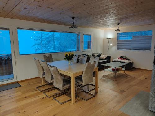 uma sala de jantar com uma mesa e cadeiras e um sofá em Chalet Matterhornsicht em Naters