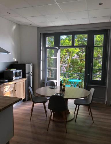 cocina con mesa y sillas en Résidence Harmonie Appartement N 3 Meublé Avec Petit Déjeuner, en Néris-les-Bains