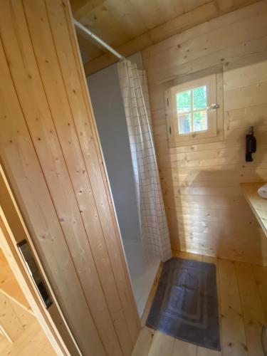 a wooden cabin with a door and a window at Camping La Ferme de Castellane in Castellane