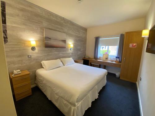 a hotel room with a large bed and a window at Dudsbury Golf Club - Hotel And Spa in Ferndown