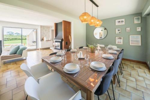 une salle à manger avec une grande table et des chaises en bois dans l'établissement TY AR MENEZ - Magnifique maison familiale de 180m proche de la plage, à Landunvez
