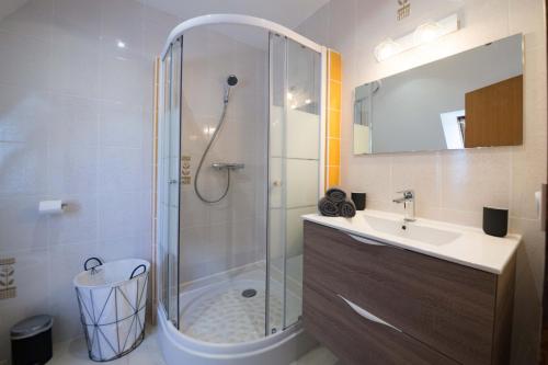 ein Bad mit einer Dusche und einem Waschbecken in der Unterkunft TY AR MENEZ - Grande maison familiale proche plage in Landunvez