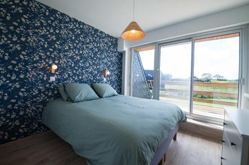 ein Schlafzimmer mit einem Bett und einer mit Blumen bedeckten Wand in der Unterkunft TY AR MENEZ - Grande maison familiale proche plage in Landunvez