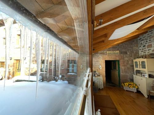 Cette chambre dispose d'une grande fenêtre avec de la neige au sol. dans l'établissement El Rincón de Golobar en Brañosera, à Brañosera