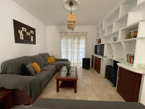 een woonkamer met een bank en een tafel bij Chalet Edén Azul in Chiclana de la Frontera