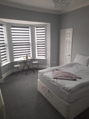 a bedroom with a bed and a table and windows at VM Holiday let in Great Yarmouth