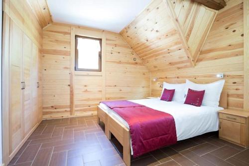 a bedroom with a bed in a wooden cabin at Etno Naselje Vrdnička kula in Vrdnik