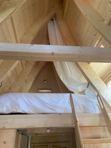 a room in a roof with a bed in it at Camping La Ferme de Castellane in Castellane