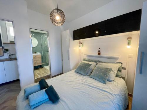 a bedroom with a large white bed with blue pillows at Homelivia Av Jean Médecin in Nice