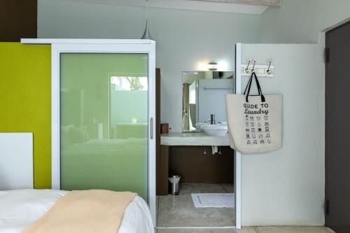 ein Schlafzimmer mit einem Bad mit einem Waschbecken und einem Kalender in der Unterkunft Atlantic-Square Guesthouse in Swakopmund