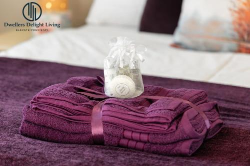 a purple towel with a bag of money on top of it at Dwellers Delight Living Ltd 2 Bed House with Wi-Fi in Loughton, Essex in Loughton