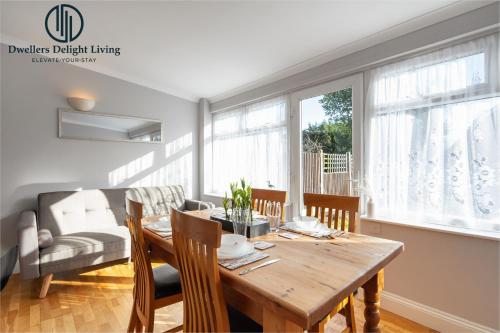 a dining room with a wooden table and chairs at Dwellers Delight Living Ltd 2 Bed House with Wi-Fi in Loughton, Essex in Loughton