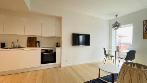 uma cozinha com armários brancos e uma mesa com cadeiras em ApartmentInCopenhagen Apartment 1527 em Copenhague