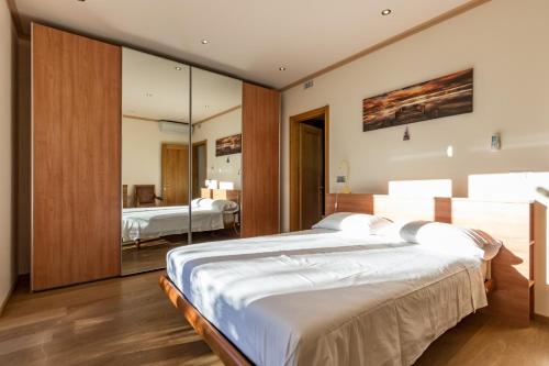 ein Schlafzimmer mit einem großen Bett und einem Spiegel in der Unterkunft Villa Rogaro Corinna in Griante Cadenabbia