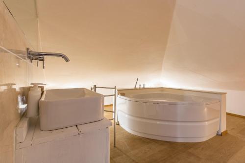 eine große weiße Badewanne im Bad mit Waschbecken in der Unterkunft Villa Rogaro Corinna in Griante Cadenabbia