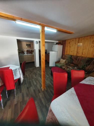 Habitación con sillas rojas, cama y mesa. en Casa Siady, en Vatra Dornei