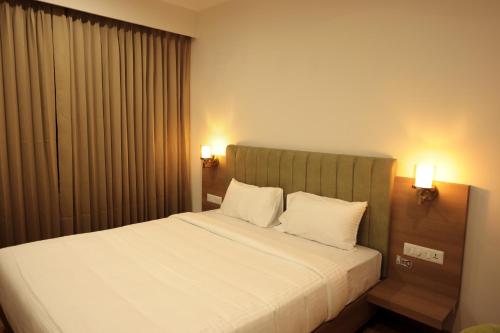 a bedroom with a bed with two white pillows at HILUX COURTYARD in Palakkad
