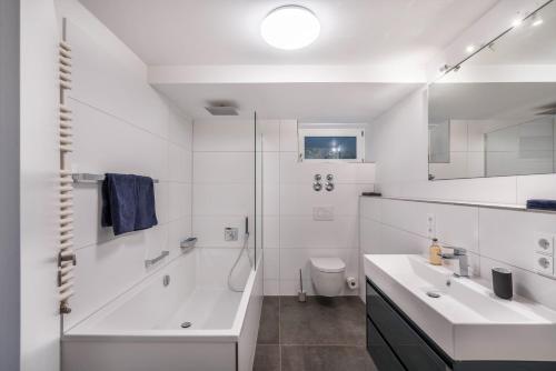 a white bathroom with a sink and a toilet at In Bayern in Warngau