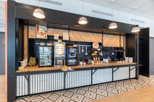 a restaurant with a counter with soda machines at B&B HOTEL Bourg-en-Bresse Viriat in Viriat