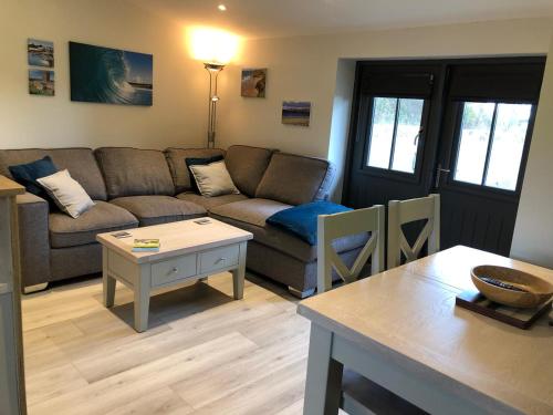 a living room with a couch and a table at Thistledown Lodge! 5 minutes from beach! Free cancellation! in Haverfordwest