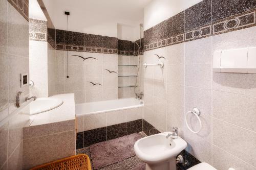 a bathroom with a sink and a toilet and a tub at Central Festival Apartment by Wonderful Italy in Sanremo