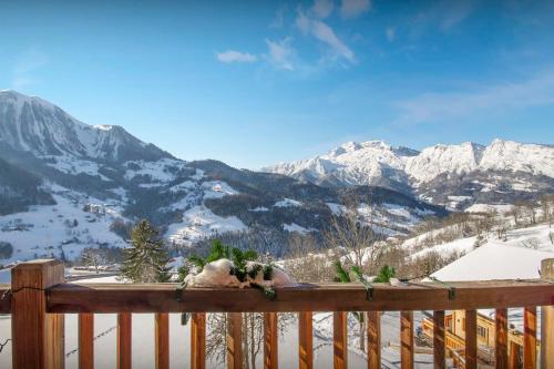 une balustrade en bois avec vue sur une montagne enneigée dans l'établissement Chalet Le Meridien - Tournette - OVO Network, à Manigod