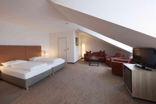 una camera con letto, divano e TV di GHOTEL hotel & living Kiel a Kiel