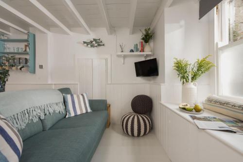 a living room with a couch and a window at Newlyn Nookery in Newlyn