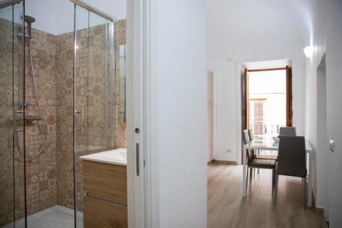 a bathroom with a shower and a table with a chair at La Maison de La Mer in Cefalù