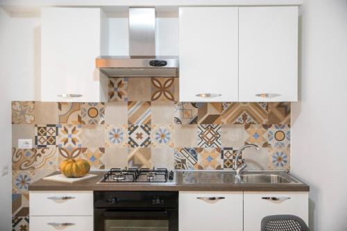 a kitchen with a sink and a stove at La Maison de La Mer in Cefalù