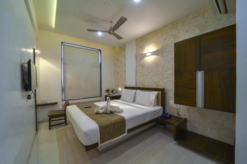 a bedroom with a large bed and a window at Hotel SRI SRI EXECUTIVE KOLHAPUR NEAR MAHALAXMI TEMPLE in Kolhapur