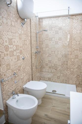 a bathroom with a toilet and a sink and a tub at La Maison de La Mer in Cefalù
