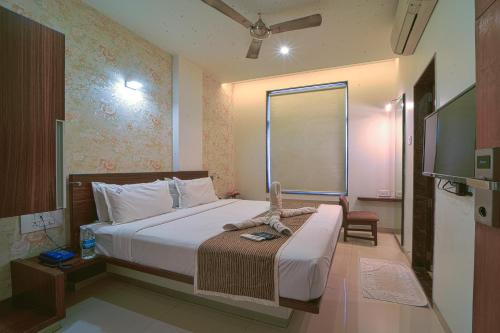 a bedroom with a large bed and a window at Hotel SRI SRI EXECUTIVE KOLHAPUR NEAR MAHALAXMI TEMPLE in Kolhapur