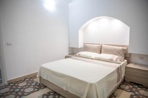 a bedroom with a bed with an arch above it at La Maison de La Mer in Cefalù