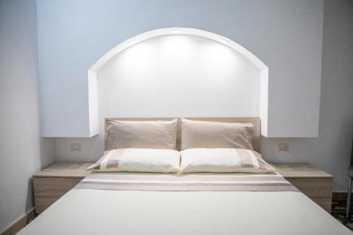 a bed in a room with an arch above it at La Maison de La Mer in Cefalù