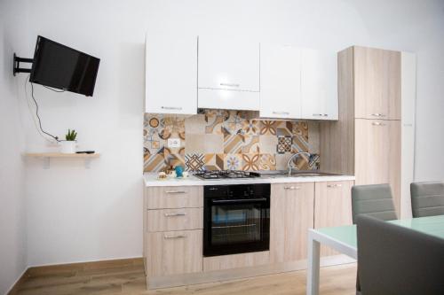 a kitchen with white cabinets and a stove top oven at La Maison de La Mer in Cefalù