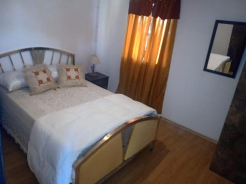 1 dormitorio con cama y espejo en la pared en Amarillo en Luján de Cuyo