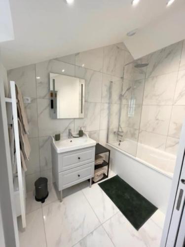 a bathroom with a sink and a shower and a tub at Suite Théodore - 2 pers in Charleville-Mézières