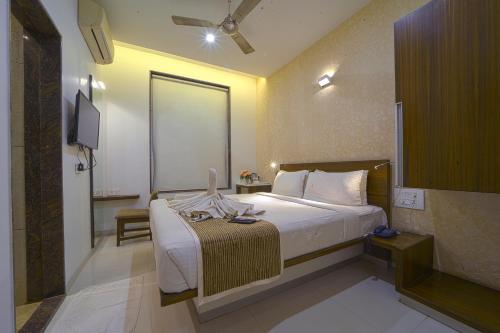 a hotel room with a bed and a television at Hotel SRI SRI EXECUTIVE KOLHAPUR NEAR MAHALAXMI TEMPLE in Kolhapur