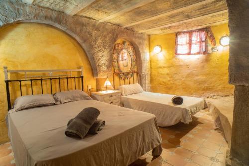 a bedroom with two beds in a stone room at 4 bedrooms villa with private pool furnished garden and wifi at Algarinejo in Algarinejo