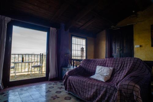 a living room with a couch and a large window at Charming Villa in Algarinejo with Private Pool in Algarinejo