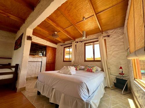 a bedroom with a bed in a room with wooden ceilings at Atacama Lodge Rukazen Spa Rústico in San Pedro de Atacama