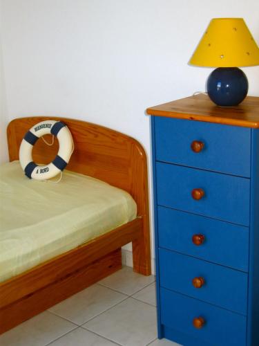 - une chambre avec un lit, une commode bleue et une lampe dans l'établissement SUNSET Joli T2 vue mer piscine SUNSET Cap d'Agde, au Cap d'Agde