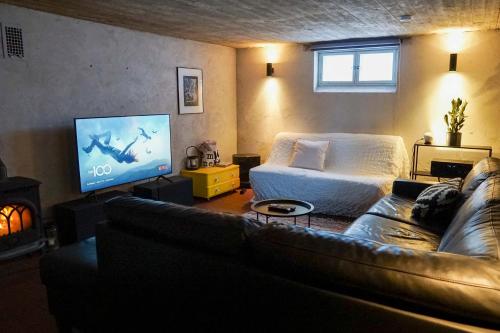 a living room with a couch and a flat screen tv at Arctic Garden Design Villa in Rovaniemi